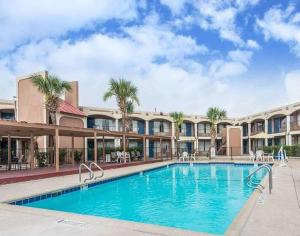 a pool at a resort with palm trees at Days Inn by Wyndham San Antonio Splashtown/ATT Center in San Antonio