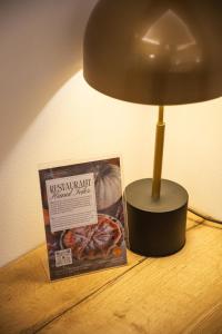 a lamp on a table next to a box and a picture at Hanul Teilor in Dăneşti