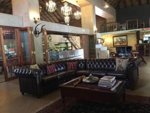 a living room with a leather couch and a coffee table at Shelanti Game Reserve in Marken