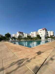 a large swimming pool with buildings in the background at ADORA Apartment in Tangier