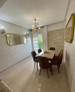a dining room with a table and chairs and a mirror at ADORA Apartment in Tangier