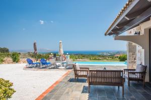 a patio with a table and chairs and a pool at Villa Resi in Vamos