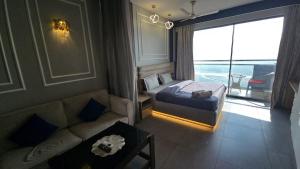 a bedroom with a bed and a couch and a window at Lake Side Drift by Luxury loft 37th floor in Noida