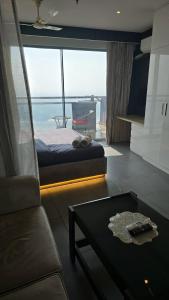 a living room with a bed and a couch and a table at Lake Side Drift by Luxury loft 37th floor in Noida