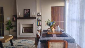 a living room with a table and a fireplace at Bhimtal Lakeview Cottage in Bhīm Tāl