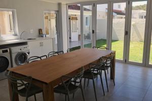 a kitchen with a wooden table and chairs at 85 The Dunes in Keurboomstrand