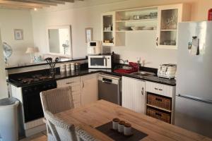 a kitchen with a table and a white refrigerator at 85 The Dunes in Keurboomstrand