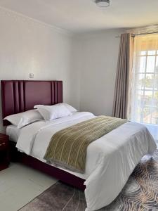a bedroom with a large bed with a large window at Bleu Haven in Kitale