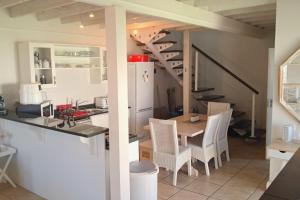 a kitchen and dining room with a table and chairs at 85 The Dunes in Keurboomstrand +8 photos
