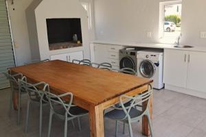 a kitchen with a wooden table and chairs at 85 The Dunes in Keurboomstrand