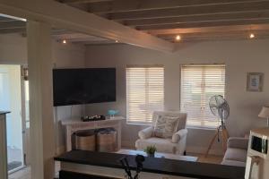 a living room with a tv and a chair at 85 The Dunes in Keurboomstrand