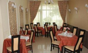 a dining room with tables and chairs with red table cloth at Hotel Coliseum in Calafat
