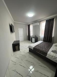 ein Schlafzimmer mit einem Bett und einem Fernseher in der Unterkunft Red Family Hotel in Vagharshapat
