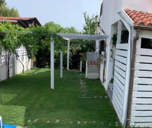 a yard with a white building and a white pergola at Camera La Cinta in San Teodoro