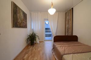 a bedroom with a bed and a potted plant at Vilnius Luxury Apartment 1 in Vilnius