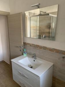 a bathroom with a white sink and a mirror at Camera La Cinta in San Teodoro