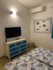a room with two beds and a television on a dresser at Camera La Cinta in San Teodoro