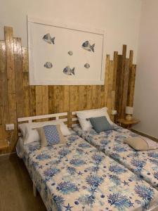 a bedroom with two beds and a wall with fish on it at Camera La Cinta in San Teodoro