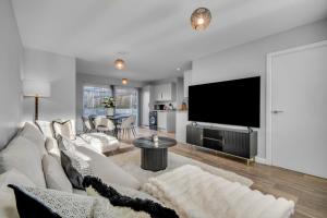 a living room with a white couch and a flat screen tv at Lovely 2-Bed House with parking in Broomfield