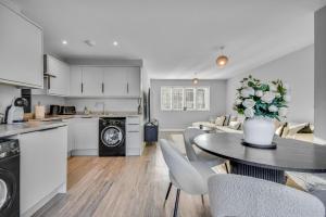 a kitchen and living room with a table and chairs at Lovely 2-Bed House with parking in Broomfield