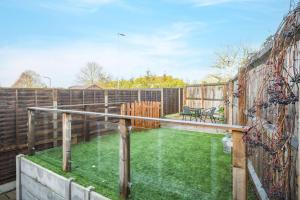a backyard with a fence and a yard withgrass at Lovely 2-Bed House with parking in Broomfield
