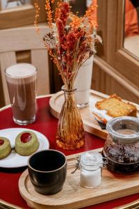 a table with a vase of flowers and a plate of food at La Dépendance in Paris