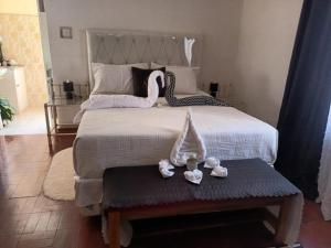 a bedroom with a bed with two swans on it at Crocodile Rock Lodge in Bulawayo +21 photos