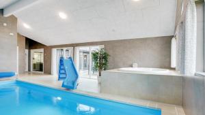 a bathroom with a swimming pool and a bath tub at Villavilla 530 - Mommark, Sydjylland in Sarup