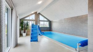 a pool with a blue slide in a room at Villavilla 530 - Mommark, Sydjylland in Sarup