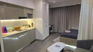 a room with a bed and a kitchen in a room at Cozy corner by Luxury loft in Noida