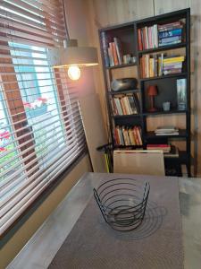 a bowl on a table in a room with a book shelf at the hobbit house in Antwerp