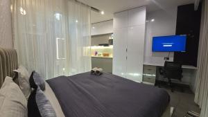 a bedroom with a bed and a flat screen tv at Cozy corner by Luxury loft in Noida