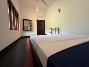 a bedroom with a large white bed in a room at Mango Three Resort in Anuradhapura