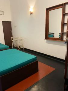 a small room with a bed and a mirror at Mango Three Resort in Anuradhapura