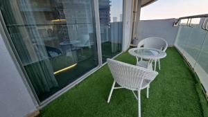 a balcony with chairs and a table on the grass at Cozy corner by Luxury loft in Noida