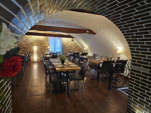 a restaurant with tables and chairs and a brick wall at Auberge Saint Martin in La Brigue