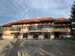 an apartment building with a red roof at K&I Panzió in Comolău