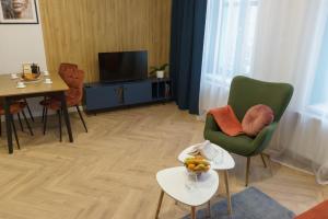 a living room with a table and chairs and a television at Willa na Dębowej in Katowice