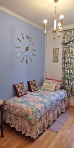 a bedroom with a bed with a clock on the wall at Dom Pod Złotym Bażantem in Kobiela