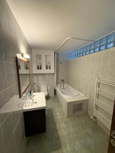 a bathroom with a tub and a sink and a bath tub at K&I Panzió in Comolău