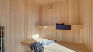 a sauna with wooden shelves and a blue towel at Villavilla 596 - Rømø, Sydjylland in Høm