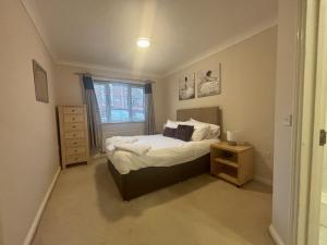a small bedroom with a bed and a night stand at Bracknell Spacious Two Bedroom Apartment in Bracknell
