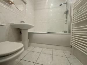 a bathroom with a sink and a toilet and a tub at Bracknell Spacious Two Bedroom Apartment in Bracknell