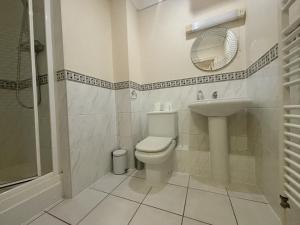 a bathroom with a toilet and a sink and a mirror at Bracknell Spacious Two Bedroom Apartment in Bracknell