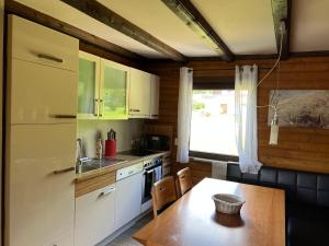 a kitchen with white cabinets and a wooden table at Haus 68 Bergblick in Arrach +25 photos