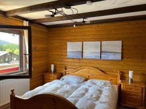 a bedroom with a bed in a wooden wall at Haus 68 Bergblick in Arrach