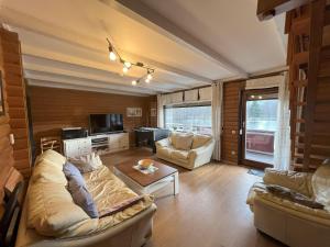 a living room with two couches and a tv at Haus 23 Seeblick in Arrach