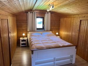 a bedroom with a bed in a wooden room at Haus 23 Seeblick in Arrach
