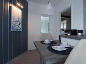 a dining room with a table with two white dishes on it at Kirchenplatz 6 Apartment 17 in Warnemünde