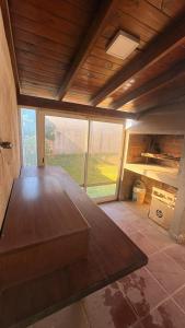 a large wooden table in a room with a large window at Malvinas Casa de Playa in Necochea